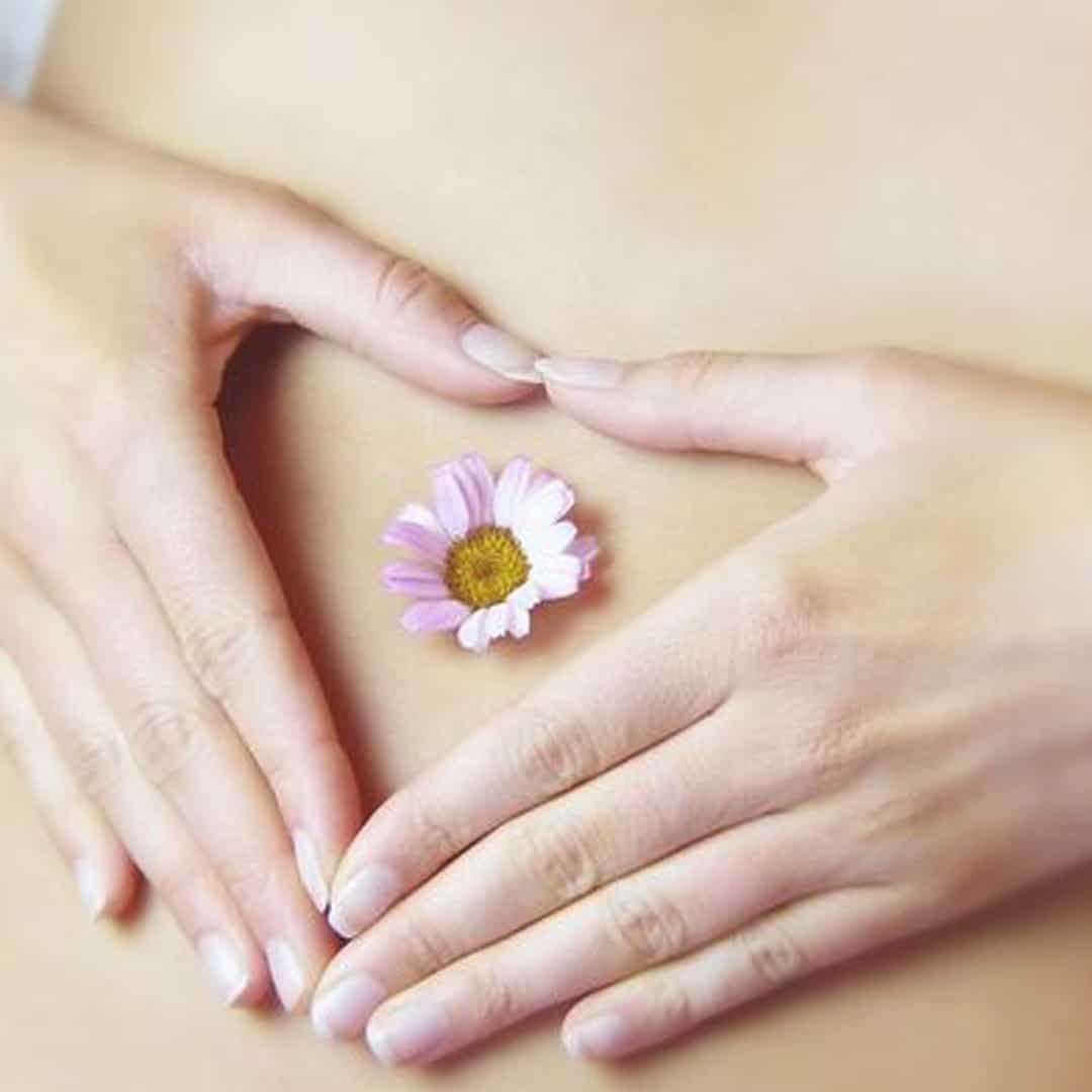 lady putting her hands in a shape of a heart on her stomach